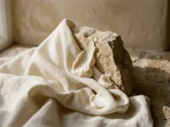 Émulsions soyeuses, lin froissé et textures sensorielles sur coupelle minérale